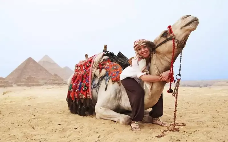 Visitors photographing the Sphinx from camel ride at Giza Pyramids